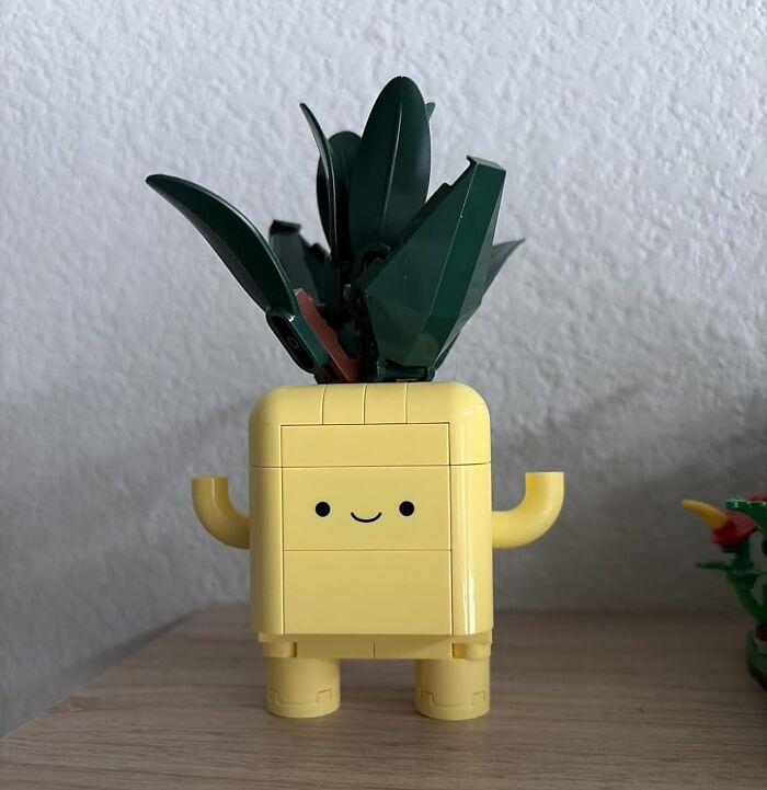 Cute yellow pineapple toy with green leaves, a smiling face, and arms, perfect as a fun stocking stuffer gift idea.