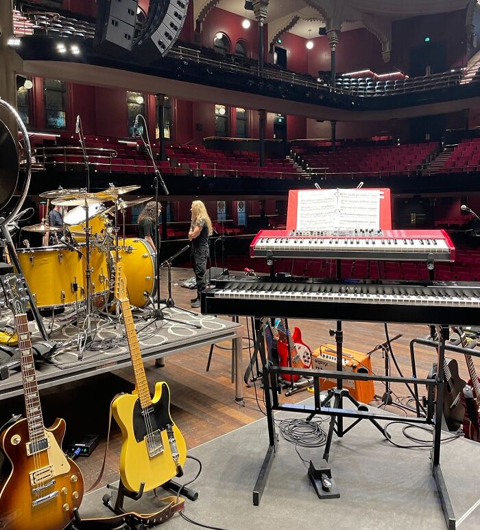 Stage setup with musical instruments including drums, guitars, and keyboards, inspiring dreams turned into reality.