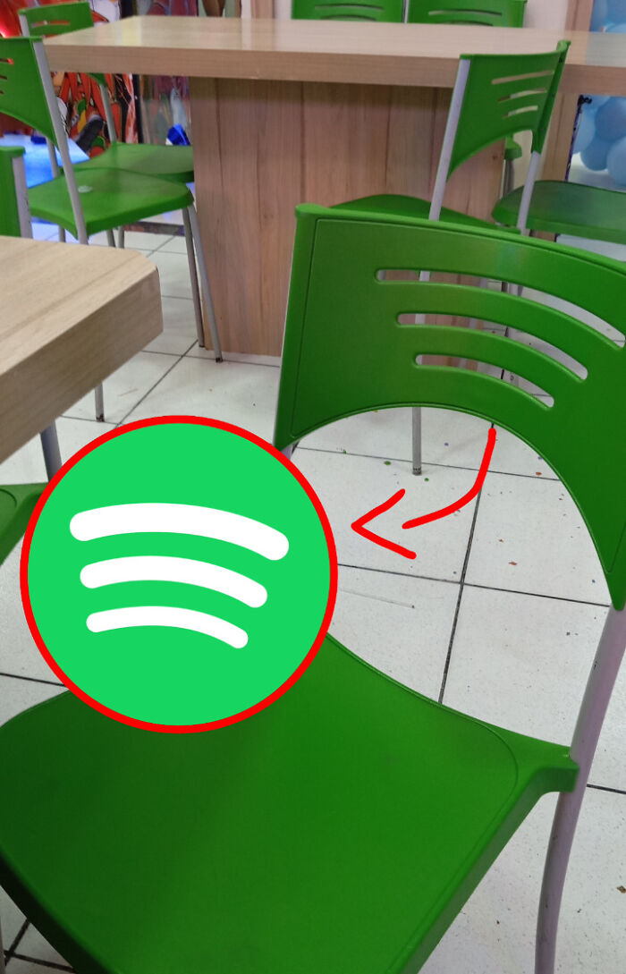 Green chair backrest shaped like Spotify logo lines in a casual dining area, showing things that look like other things.