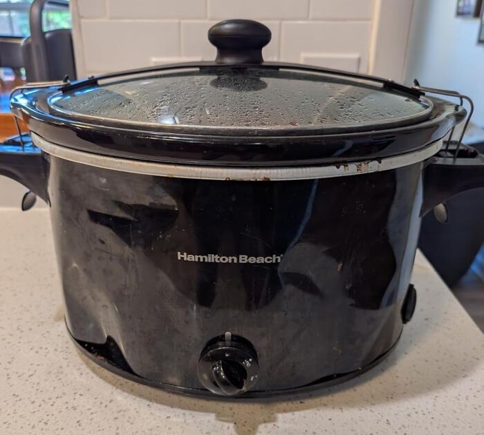 Hamilton Beach slow cooker on kitchen countertop with steamed condensation on glass lid during Black Friday deals week.