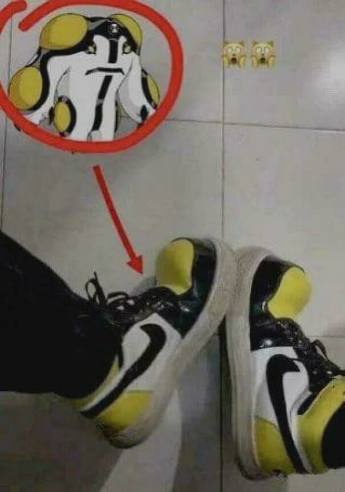 Yellow and black sneakers on tiled floor that look like or remind people of a cartoon character face pattern.