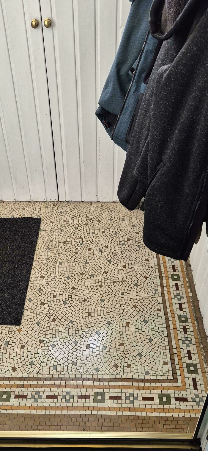 Intricate mosaic tile floor in the entryway of a beautiful old house showcasing craftsmanship standing the test of time.