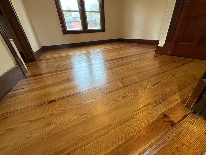 Polished wooden floor in a bright room of a beautiful old house showcasing craftsmanship and timeless design.