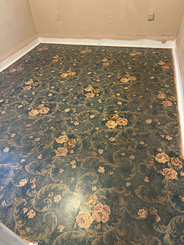 Worn floral carpet in an empty room showcasing the charm of old houses and timeless craftsmanship details.