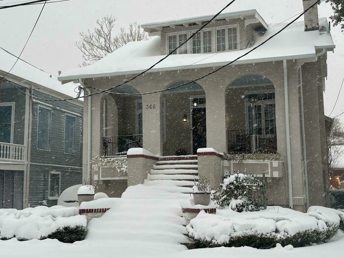 Snow-covered beautiful old house with classic architectural details showcasing timeless craftsmanship in winter.