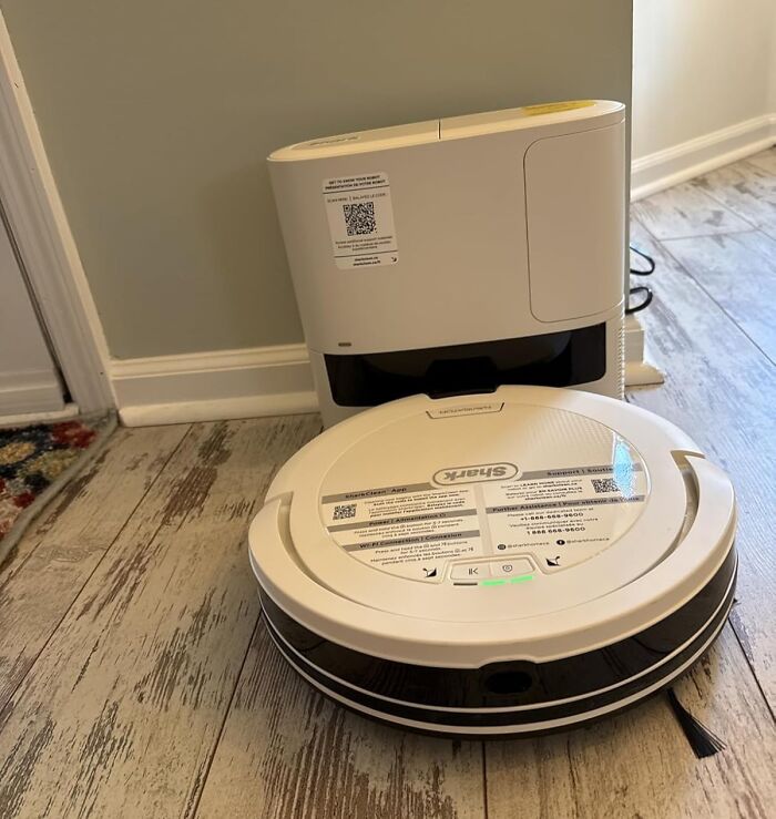 Robot vacuum cleaner docked on wooden floor, highlighting main character splurges of Black Friday week deals.