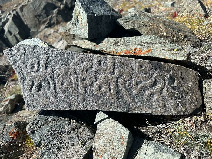 Ancient carved stone with inscriptions found in a rocky landscape, a fascinating archeology discovery from the world.