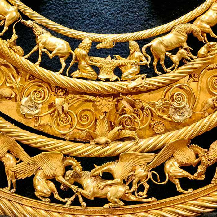 Intricate gold archeology find featuring detailed animal and human figures from an ancient civilization, showcasing craftsmanship.