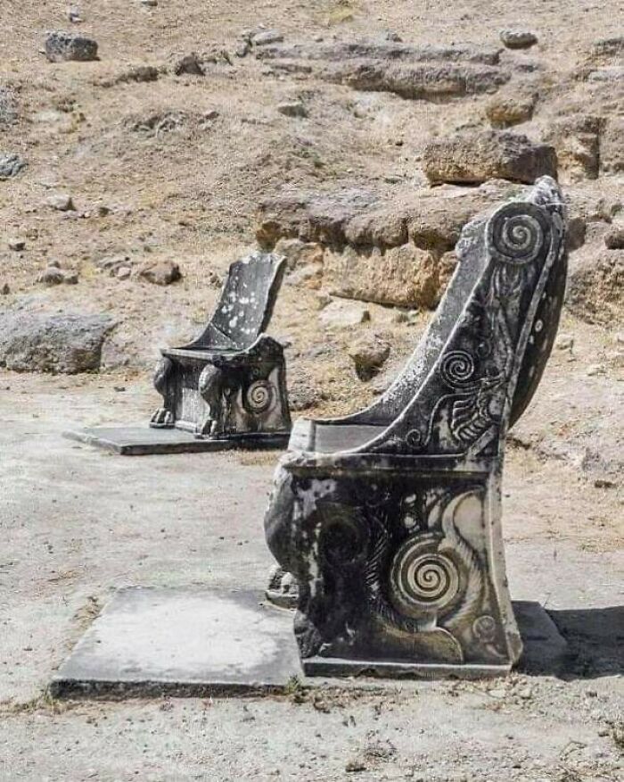 Ancient stone chairs with intricate spiral carvings at an archeology site showcasing fascinating finds from around the world.