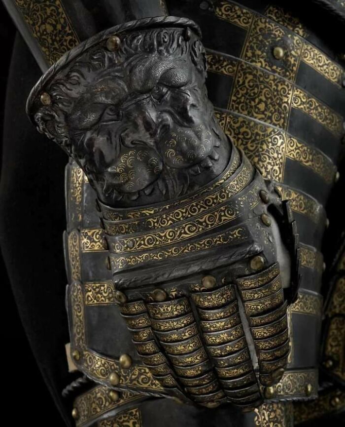 Close-up of ornately decorated medieval armor gauntlet featuring detailed lion motifs, a fascinating archeology find.