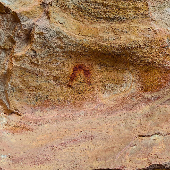 Ancient rock art painting on a weathered stone surface showcasing fascinating archeology finds from around the world.