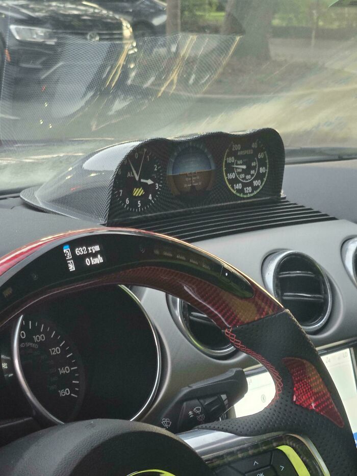 Car interior with a modified dashboard display showing cockpit instruments, an example of stupidity on wheels customization.