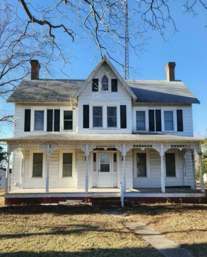 A beautiful old house showcasing craftsmanship with detailed woodwork and classic architectural features under a clear blue sky.