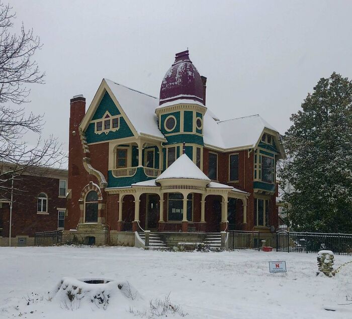 Victorian old house with intricate craftsmanship, snow-covered roof, and detailed woodwork showcasing timeless architectural beauty.