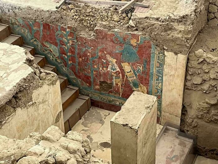 Ancient archeology site with colorful murals on stone walls and stairs, showcasing fascinating historical finds worldwide.