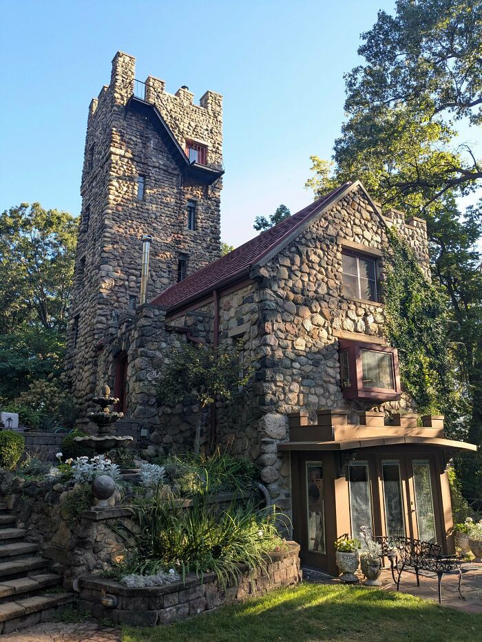 Stone old house with tower surrounded by greenery showcasing craftsmanship that has stood the test of time in a peaceful setting