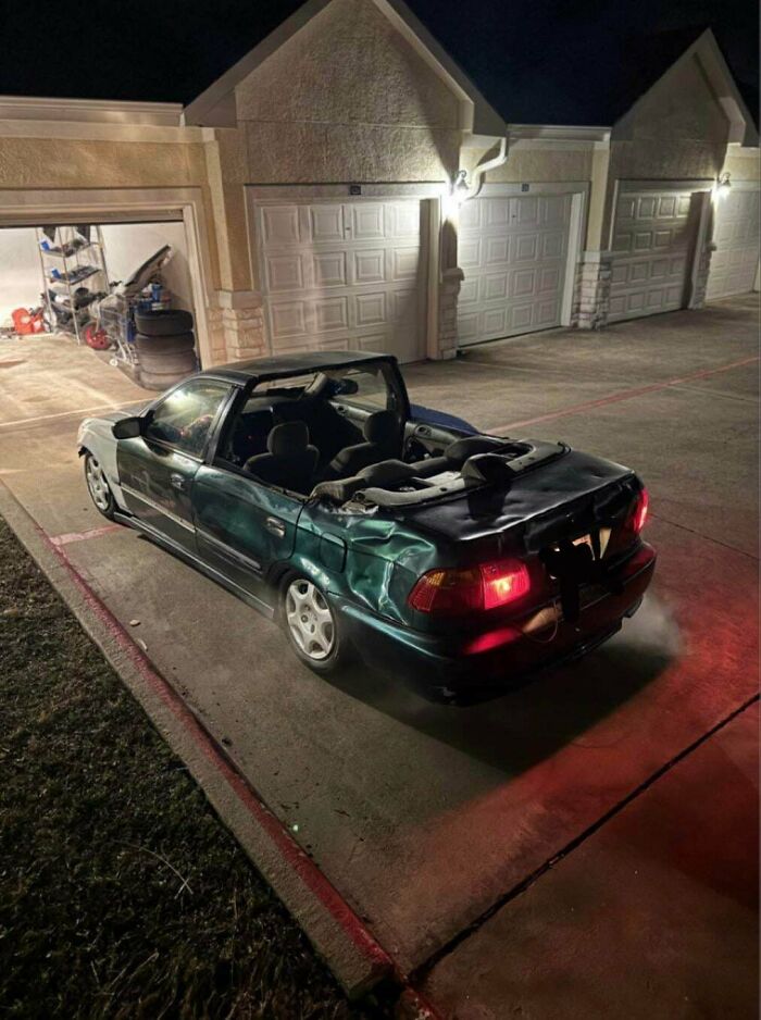 Damaged car missing its roof parked near garages at night, an example of stupidity on wheels fails to look cooler.
