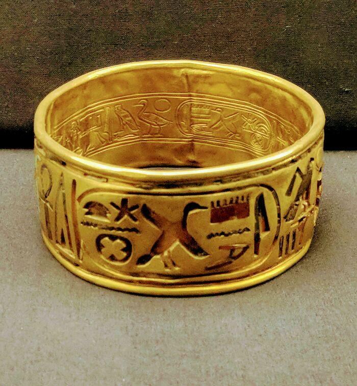 Ancient gold bracelet featuring intricate hieroglyphics, a fascinating archeology find from around the world.