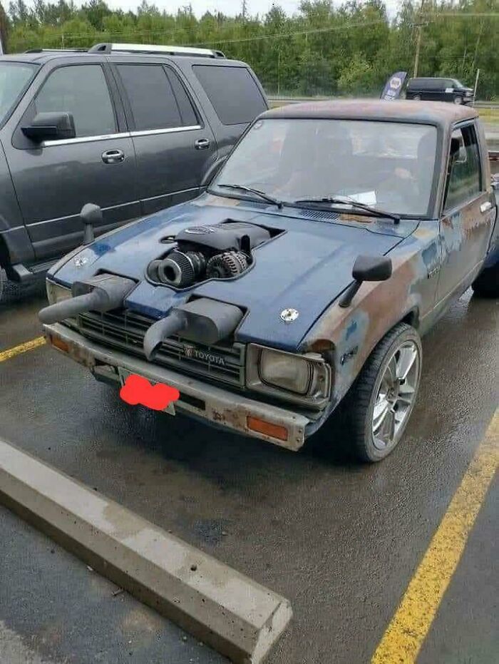 Old Toyota with unconventional engine modification and exhaust pipes making the car cooler but looking like stupidity on wheels.