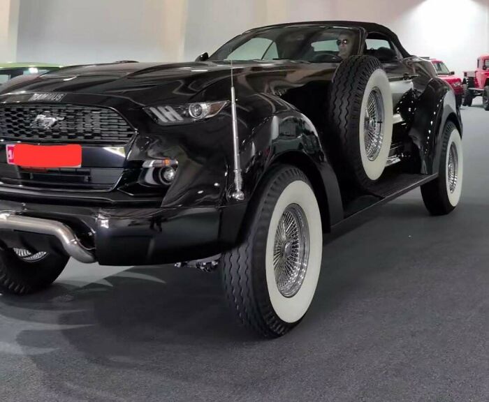 Black custom car with oversized whitewall tires and unusual design, an example of failed attempts to make cars cooler.