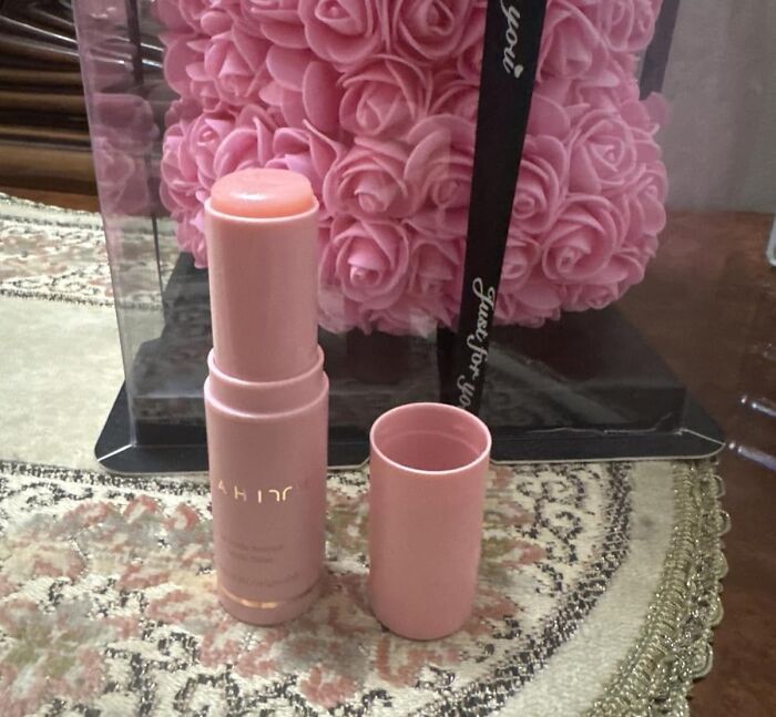 Pink beauty stick with cap off on patterned surface, highlighting holy grail beauty deals for Black Friday restocking.