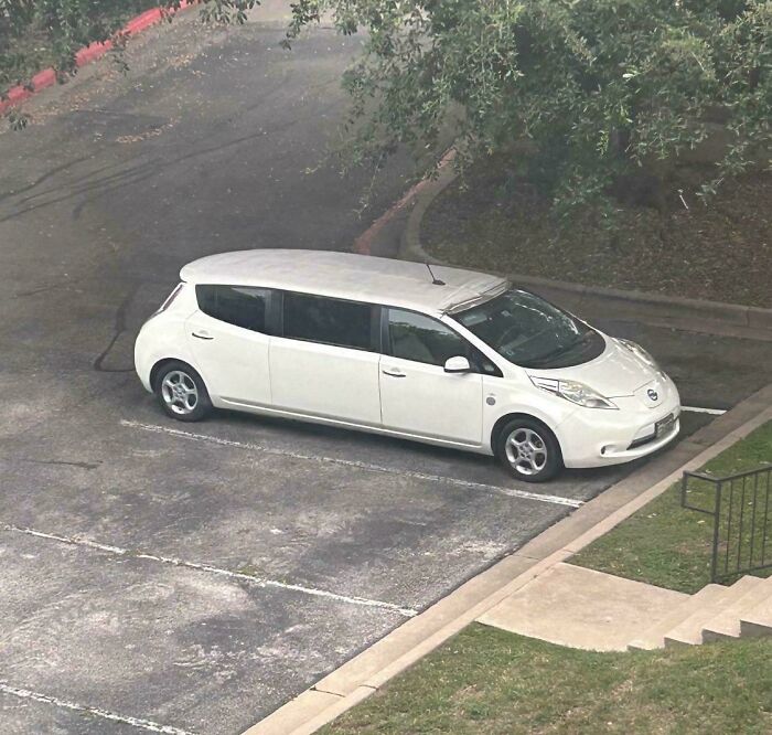 Long white car stretched to look cooler but ended up as an unusual example of stupidity on wheels parking in a lot.