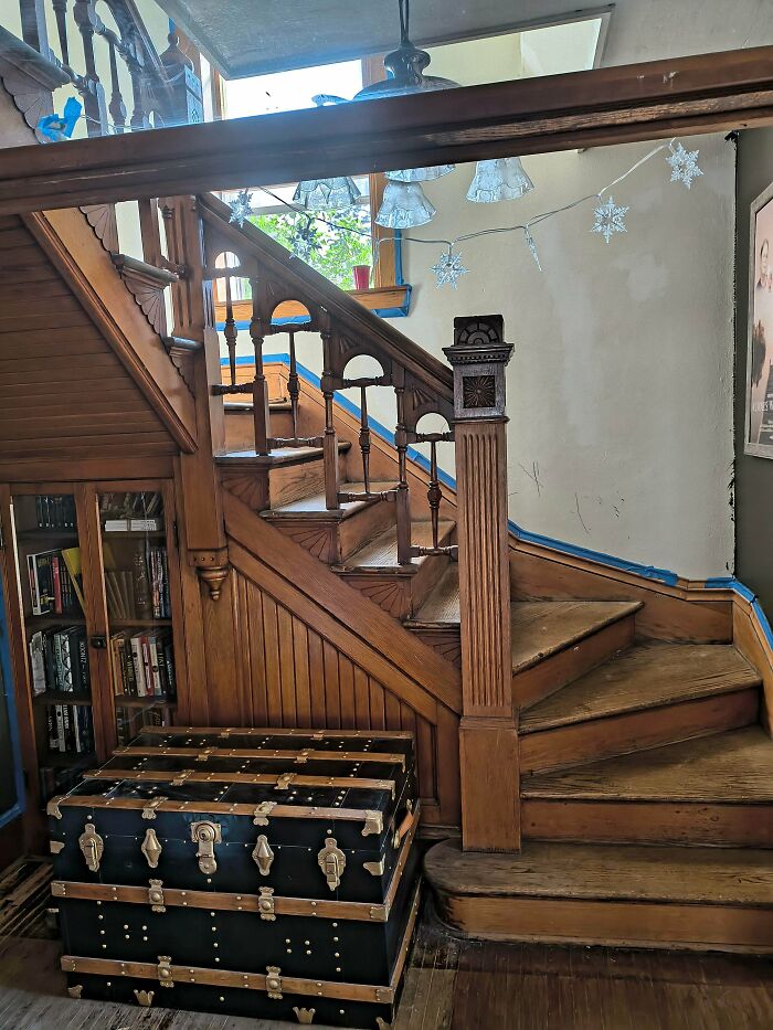 Wooden staircase and vintage trunk in a beautiful old house showcasing timeless craftsmanship and historic architectural details.