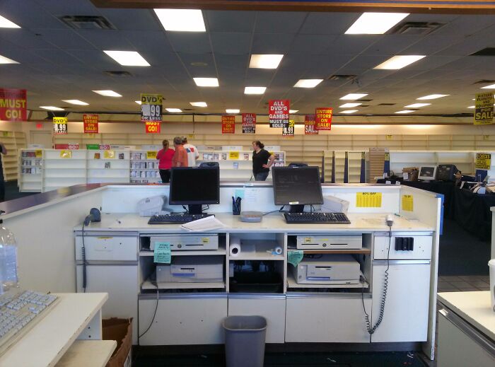 Empty retail store checkout counter with computers and employees in the background, illustrating employee walkout pranks.