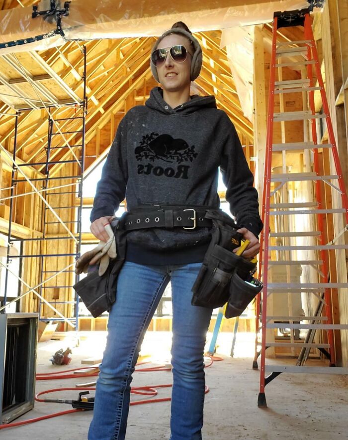 Woman wearing tool belt and headphones at construction site, showcasing people turning big and small dreams into reality.