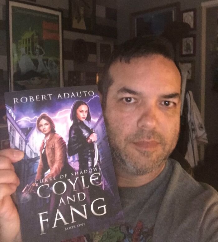 Man proudly holding a newly published book, showcasing one of the moments people turned their dreams into reality.