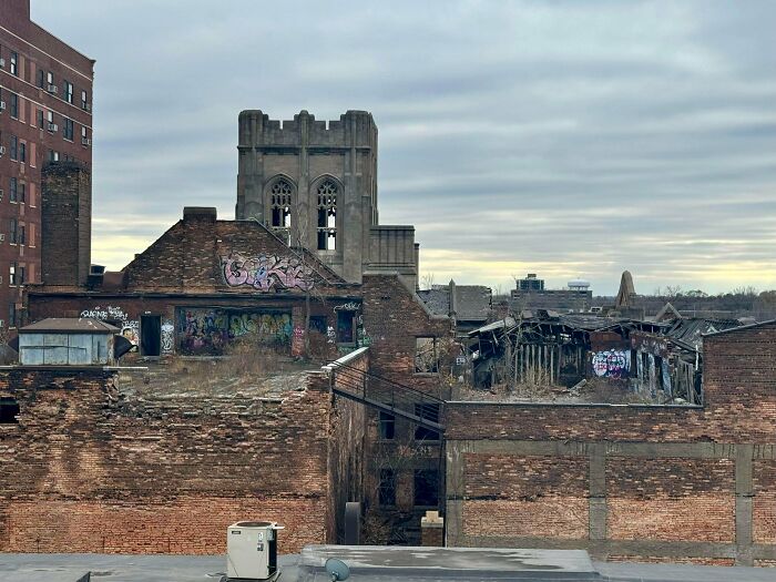 Urban decay in a cityscape with old, graffiti-covered buildings and a cloudy sky, illustrating Miami's contrast to online hype.