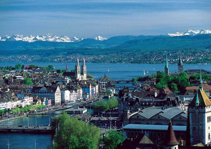 Scenic view of a European city with lakes and mountains, unrelated to Miami or its online hype perception.