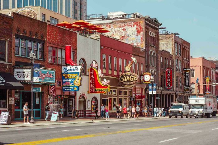 Street view of a busy urban area with colorful signs and people walking, highlighting Miami city atmosphere.