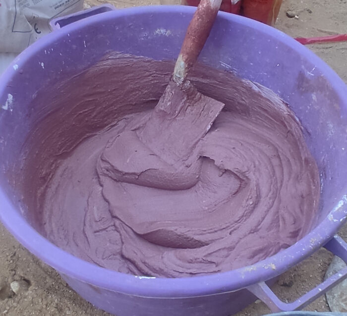 Purple bucket filled with thick paste and a wooden spatula, illustrating forbidden foods to resist eating for your own good.