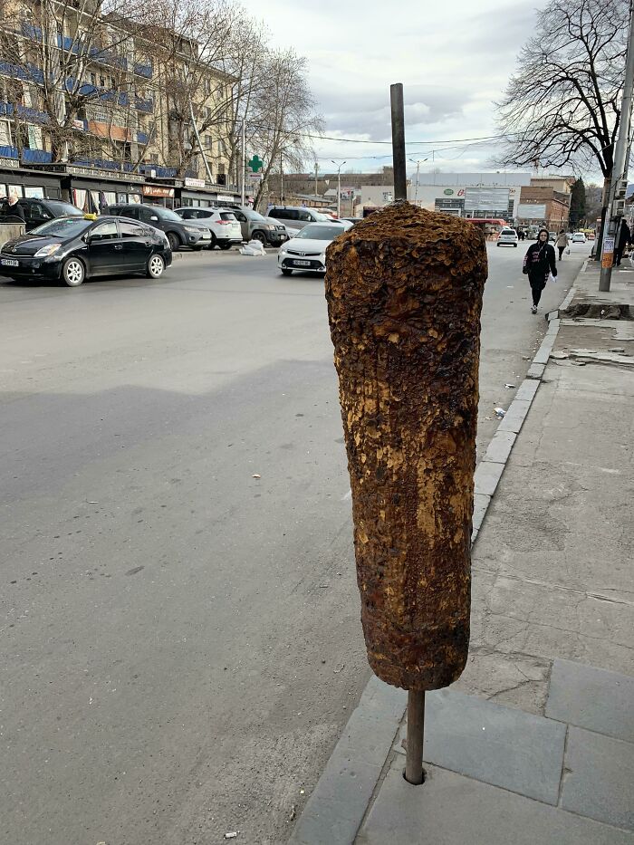 Large vertical roasted meat on a skewer by the roadside, illustrating one of the forbidden foods to resist eating.