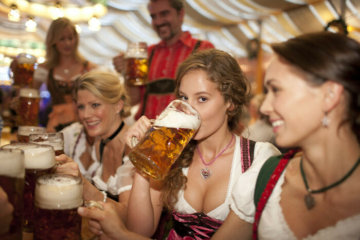 Group of people in traditional attire enjoying beer at a festive gathering, highlighting Miami social nightlife scenes.