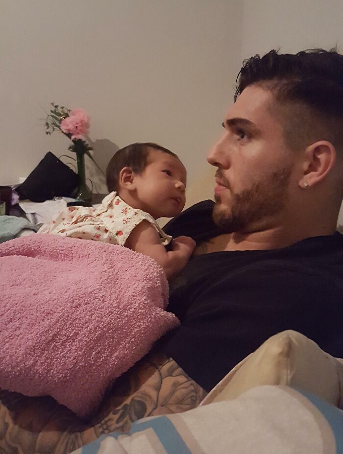 A man holding a baby wrapped in a pink blanket, sharing a quiet moment that inspires internet dreams come true.