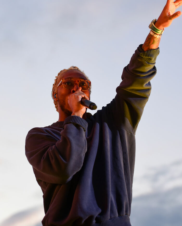Future performing on stage wearing sunglasses and a dark sweatshirt during a live concert bio and career highlights.