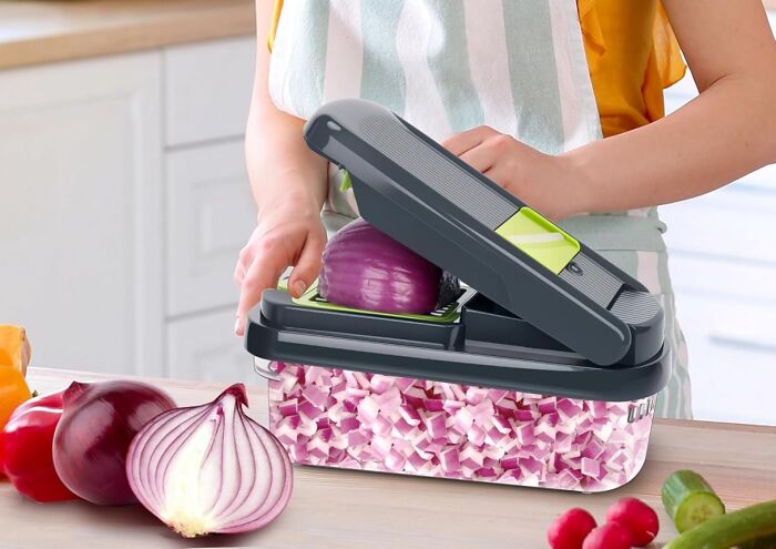 Person using a kitchen mandoline slicer to chop onions with Black Friday kitchen deals for cooking enthusiasts