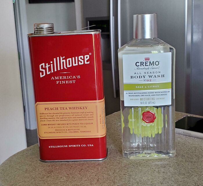 Red Stillhouse peach tea whiskey can next to a bottle of Cremo sage and citrus body wash on a kitchen counter forbidden foods warning.