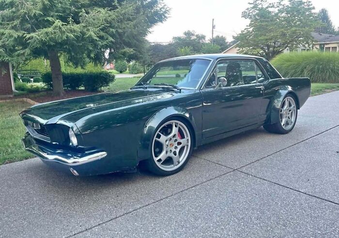 Classic car with modern oversized wheels parked on a suburban street, showing an attempt to make the car cooler.