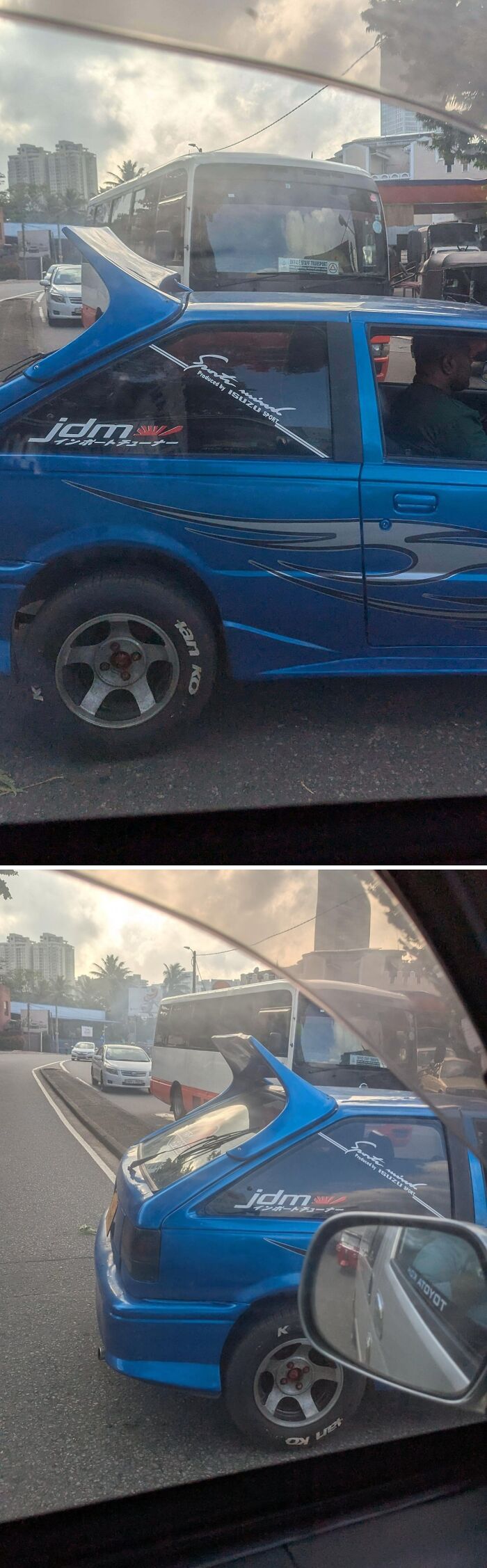 Blue car with oversized rear spoiler and Japanese-style decals, an example of stupidity on wheels car modifications on the road.