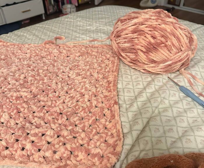 Chunky pink yarn being crocheted into a square piece showing texture, unrelated to forbidden foods keyword topic.