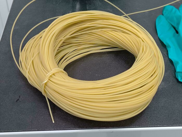 Close-up of a coiled bundle of uncooked pasta, an example of forbidden foods to resist eating for health.