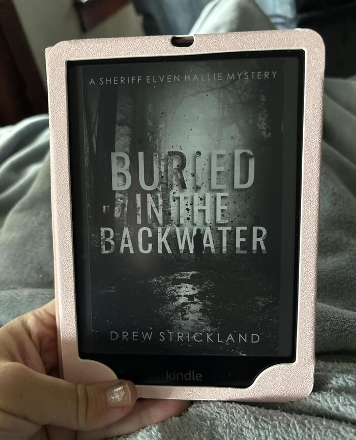 Kindle e-reader held in hand displaying a mystery book cover, showcasing Black Friday tech deals for readers and tech lovers.