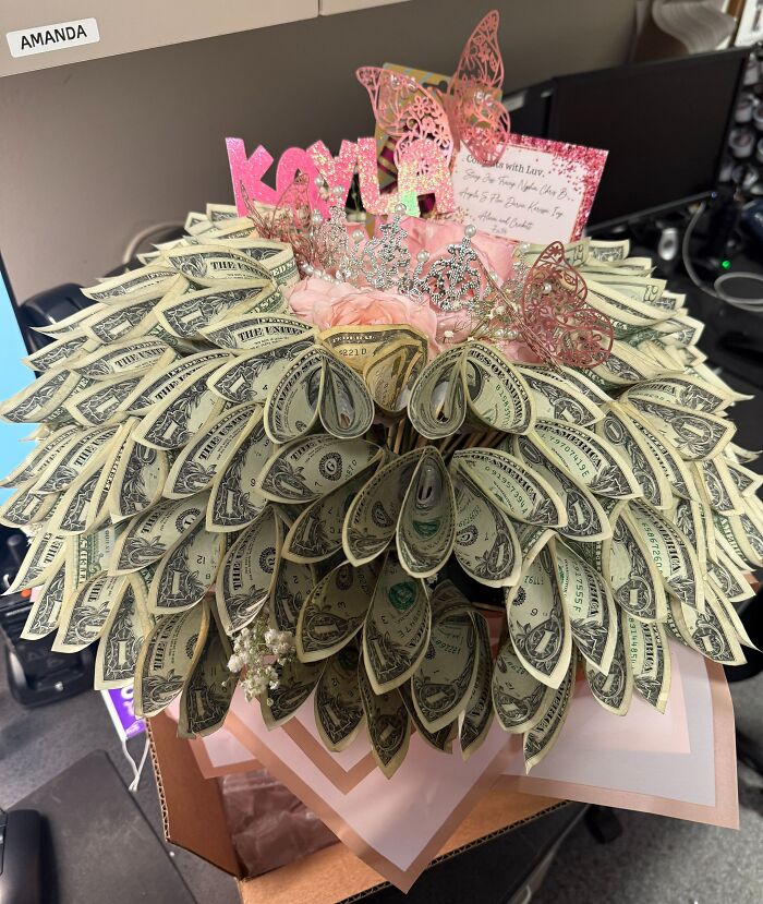 Bouquet made of folded dollar bills and pink decorations, a creative prank by employees with jokes and zero regrets.