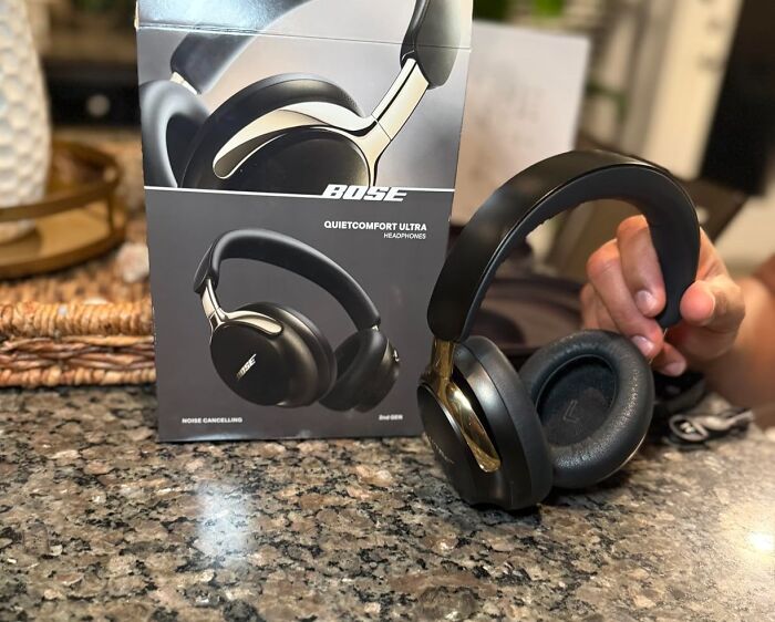 Bose QuietComfort Ultra headphones held by hand on countertop next to box featured on Alix Earle Amazon Black Friday deals.