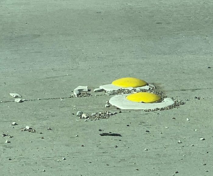 Street art showing two realistic fried eggs c*****d on the ground, highlighting forbidden foods you should resist eating.