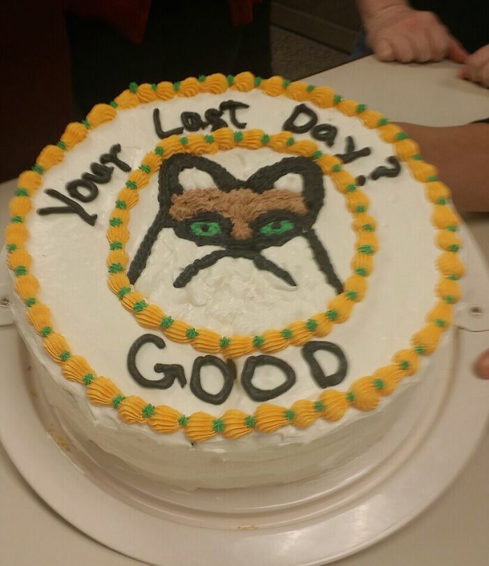 Farewell cake with a grumpy cat face and the message your last day good, a playful employee prank.
