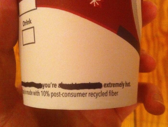 Hand holding a cup with a censored funny message, illustrating employees who walked out with jokes and pranks.